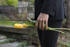 mourning man bringing tulips cemetery
