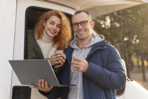 smiley couple with laptop medium shot
